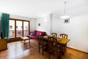 ein Esszimmer mit einem Tisch, Stühlen und einem Sofa in der Unterkunft Apartaments Les Terrasses del Tarter in El Tarter