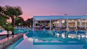 una piscina con tavoli e sedie in un resort di Tritone LUXURY HOTEL THERMAE & SPA ad Abano Terme