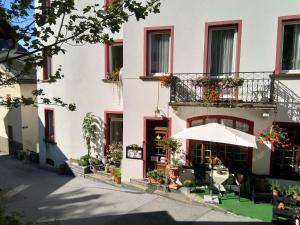 ein weißes Gebäude mit einem Schirm davor in der Unterkunft Hotel Escher in Leukerbad