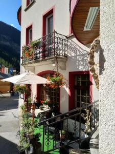 un edificio con una mesa y una sombrilla delante de él en Hotel Escher en Leukerbad