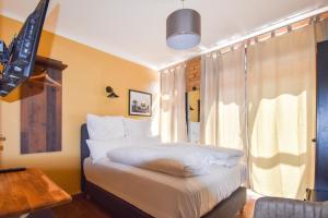 a bedroom with a bed with white sheets and a window at Boutique Hotel Sena in Berlin