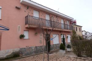 a pink building with a tree in front of it at Hostal Sali in Pelabravo