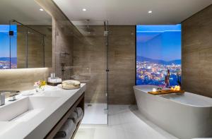 a bathroom with a tub and a sink and a shower at Grand Hotel Millennium Sofia - The Most Spacious Rooms in Sofia, Secured Underground Parking in Sofia