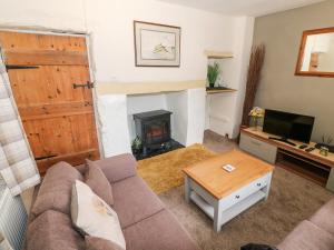 a living room with a couch and a fireplace at Rhiw Afallen in Caernarfon