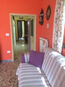 a couch in a living room with orange walls at B&B NEL VERDE in Montesano sulla Marcellana