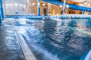 a group of people swimming in a swimming pool at Hotel Gołębiewski Białystok in Białystok