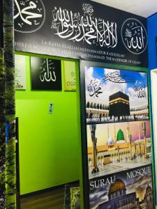 a sign for a mosque with a green wall at Orchid Haven in Cameron Highlands