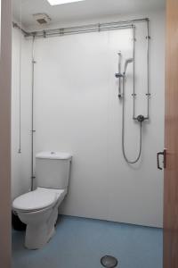 a bathroom with a toilet and a shower at YHA Broad Haven in Broad Haven