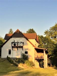 Casa blanca grande con porche y balcón en Camping Bystry, en Giżycko