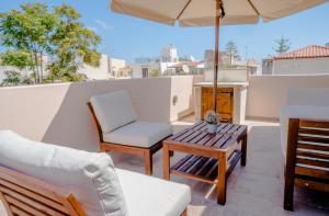 a patio with a table and chairs and an umbrella at Palazzino d Irene in Rethymno Town