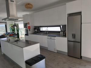 una cucina con mobili bianchi e un piano di lavoro di Cairnvillas - Villa Solar C37 Luxury Villa with Swimming Pool near Beach ad Aljezur