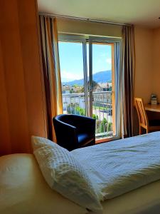 a hotel room with a bed and a large window at Das smarte Hotel garni in Höchst