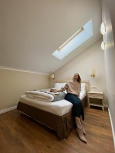 a woman sitting on a bed in a room at Business Hotel Vremena Goda in Moscow