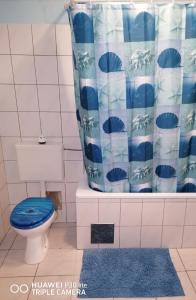 a bathroom with a blue toilet and a shower curtain at Studio apartment Meli in Ogulin