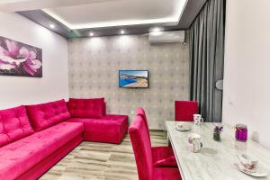 een woonkamer met een rode bank en een tafel bij De Lux Apartments Luka in Bar