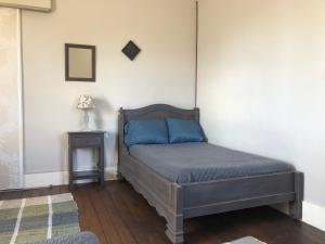 Un dormitorio con una cama con sábanas azules y una mesa. en appartement Saint-Antoine, en Toulon-sur-Arroux