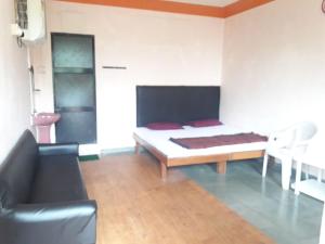 a bedroom with a bed and a couch in it at MTDC Meghdhanush park in Igatpuri