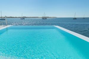 a swimming pool in the middle of the water at Grand House - Relais & Chateaux in Vila Real de Santo António
