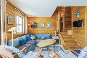 a living room with a couch and a table at Residence les chalets de Flaine Hameau - maeva Home in Flaine