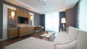 uma sala de estar com um sofá e um lavatório em Sueno Hotels Deluxe Belek em Belek
