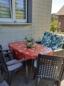 a table with a red table cloth on a patio at Pusteblume in Hain