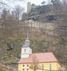 a yellow and white building with a clock tower on a hill at Pusteblume in Hain