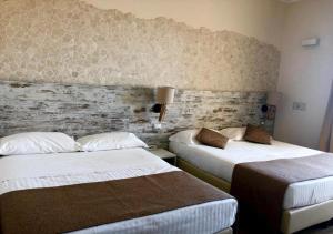 a hotel room with two beds and a brick wall at Hotel Life in Rimini