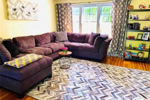 a living room with a purple couch and a rug at Mi casa su casa in Cheektowaga