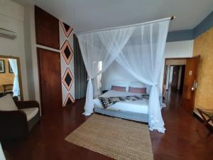 a bedroom with a bed with a canopy at FIGTREE GUESTHOUSE in Maputo