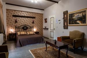 a bedroom with a bed and a couch and a table at Ξενώνας Γούσιας in Ioannina