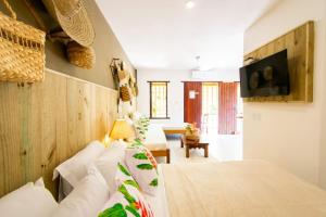 a hotel room with a bed and a tv at Pousada Por do Sol in Trancoso