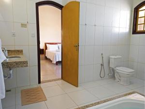 een badkamer met een douche, een toilet en een wastafel bij Arraial da Lage Hospedaria in Resende Costa