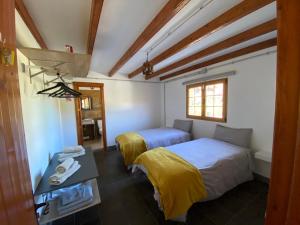 ein Zimmer mit zwei Betten und einem Tisch und einem Fenster in der Unterkunft La cara Luna in Santa Brígida