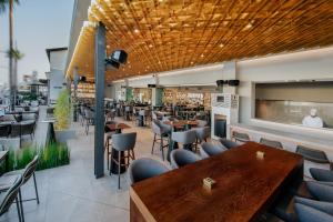 a restaurant with wooden tables and chairs at Napa Plaza Hotel (Adults Only) in Ayia Napa