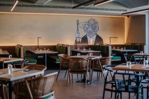 a restaurant with tables and chairs with a mural on the wall at Napa Plaza Hotel (Adults Only) in Ayia Napa