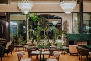a restaurant with tables and chairs and chandeliers at Napa Plaza Hotel (Adults Only) in Ayia Napa