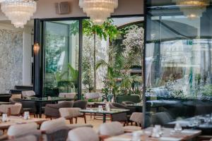 a restaurant with tables and chairs and a large window at Napa Plaza Hotel (Adults Only) in Ayia Napa