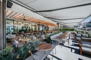 an outdoor patio with tables and chairs and a restaurant at Napa Plaza Hotel (Adults Only) in Ayia Napa