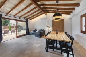 a living room with a wooden table and chairs at Stunning Villa C'an Payeras in Port de Pollensa