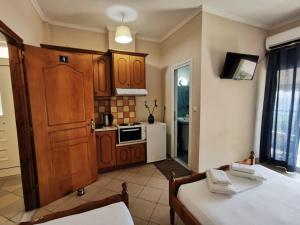 a kitchen with wooden cabinets and a bed in a room at Brb rooms in Himare