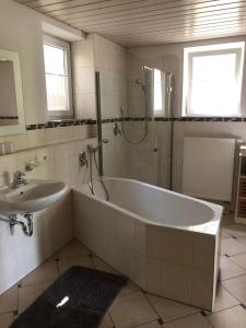 a bathroom with a tub and a sink and a shower at Ostallgäu in Ruderatshofen +5 photos