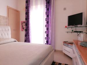 ラグーザにあるCappucciniのベッドルーム(ベッド1台、テレビ、紫色のカーテン付)