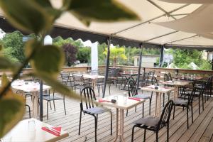 a row of tables and chairs on a deck at Le Risle - Hôtel in Montfort-sur-Risle