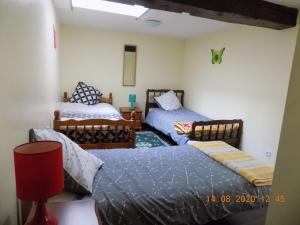 a bedroom with two beds and a red stool at Les Papillons in Vrolle