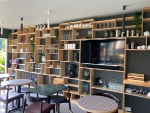 a library with a tv and tables and chairs at Rockmount Rooms & Apartment in Tavistock