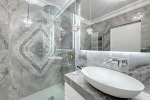 bagno con lavandino bianco e doccia di Dom & House - Apartments Navio Estate a Danzica