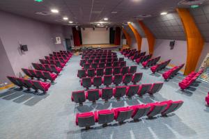 un auditorium vide avec des chaises rouges dans une pièce dans l'établissement Domaine de Mont-Evray, à Nouan-le-Fuzelier