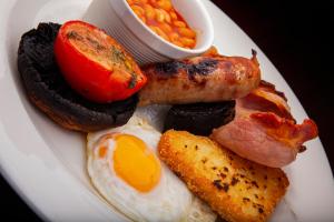 a plate of breakfast food with eggs bacon and beans at The Swan at Grasmere- The Inn Collection Group in Grasmere +65 photos