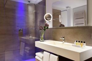 a bathroom with a sink and a vase of flowers at Borgobrufa Spa Resort Adults Only in Brufa