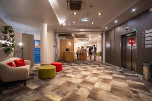 um corredor com um hall de entrada com pessoas ao fundo em Ibis Hotel Plzeň em Plzeň
